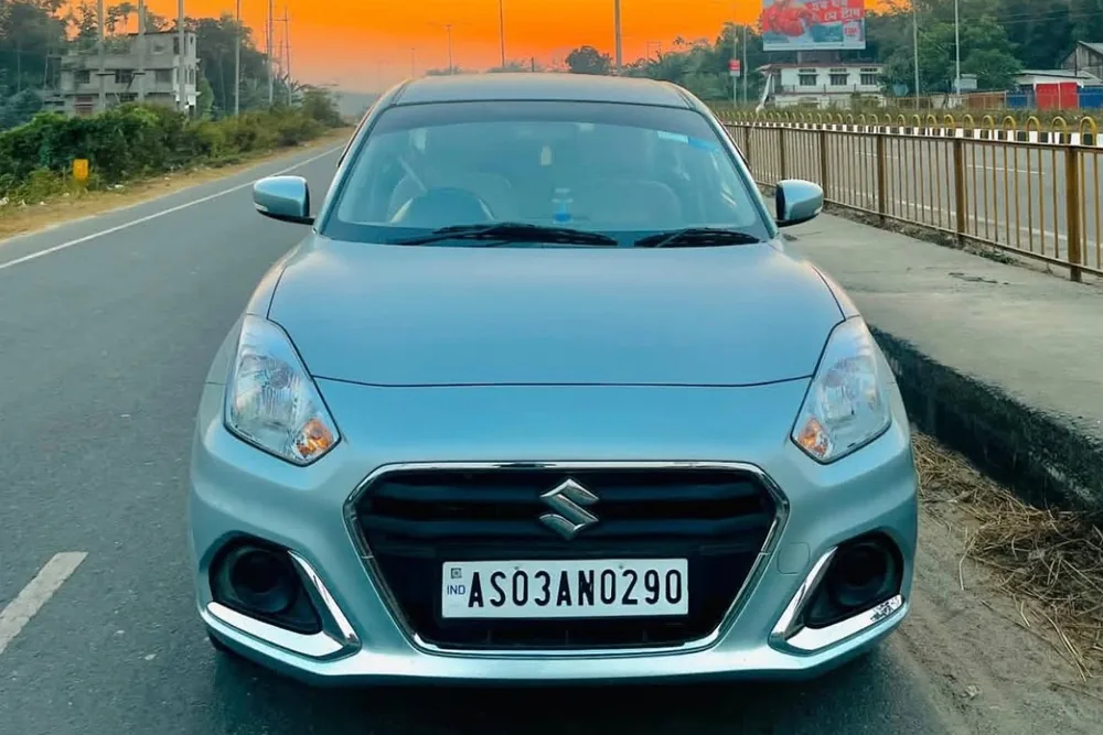Real MD Cabs Maruti Suzuki Dzire sedan parked on the highway at sunset